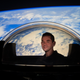 Inspiration4 crewmember Jared Isaacman peering out from the Dragon Cupola.